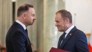 Poland's President Andrzej Duda (left) hands the assignment document to Donald Tusk to designate him as Poland's Prime Minister, during a formal swearing-in ceremony at the Presidential Palace in Warsaw, Poland, on December 13, 2023. (Photo by Wojtek Radwanski / AFP)