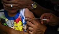 (Files) A boy accompanied by his father receives a dose of the measles and rubella vaccine from medical personnel at a community health center in the Lidice neighborhood of Caracas, on August 17, 2022. (Photo by Yuri Cortez / AFP)