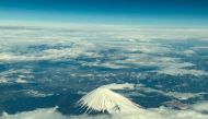 This aerial view of Mount Fuji, Japan's highest peak at 3,776 meters (12,388 feet), is seen from the window of a flight from Tokyo to Hong Kong, above Shizuoka Prefecture on March 1, 2024. (Photo by Philip FONG / AFP)
