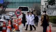 Medical workers walk outside a hospital in Seoul on February 29, 2024. (Photo by Anthony WALLACE / AFP)
