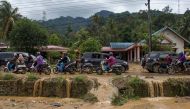 Motorists drive through a muddy road following flash flooding in Pesisir Selatan Regency, West Sumatra on March 9, 2024. (Photo by REZAN SOLEH / AFP)