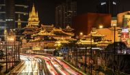 This long exposure picture shows traffic along a road leading to the Jing'an Temple in Shanghai on March 9, 2024. (Photo by Hector RETAMAL / AFP)
