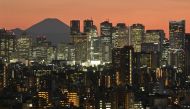 A general view shows Japan's highest mountain, Mt. Fuji (3,776m or 12,388 feet) and skyscrapers in Tokyo's Shinjuku area at sunset on March 18, 2024. (Photo by Kazuhiro NOGI / AFP)

