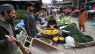 File: People buy vegetable at a market in Islamabad on February 3, 2023. - Pakistan's Prime Minister Shehbaz Sharif said February 3 the government would have to agree to IMF bailout conditions that are 