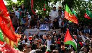 Supporters of former Prime Minister Imran Khan and Pakistan Tehreek-e-Insaf (PTI) party take part in a protest rally for the release of their leader Khan, in Peshawar on March 31, 2024. (Photo by Abdul Majeed / AFP)