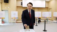 South Korea's President Yoon Suk Yeol casts his ballot during early voting at a polling station in Busan on April 5, 2024, ahead of next week's parliamentary elections.  (Photo by YONHAP / AFP)
