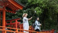 A woman takes photographs at Nezu Shrine in Tokyo on April 17, 2024. (Photo by Yuichi YAMAZAKI / AFP)