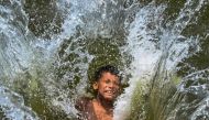 A child playfully takes a dip in a lake to get respite from the heat on a summer afternoon in Dhaka on April 29, 2024. (Photo by Munir Uz Zaman / AFP)
