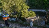 A displaced family carry their belongings to tents at a makeshift camp after fleeing from their flood hit homes following heavy rains in Charsadda district of Khyber Pakhtunkhwa province on April 17, 2024. (Photo by Abdul Majeed/ AFP)

