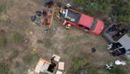 Aerial view showing rescue workers, forensics, and prosecutors preparing to enter a waterhole where human remains were found near La Bocana Beach, Santo Tomas delegation in Ensenada, Baja California State, Mexico, on May 3, 2024. (Photo by Guillermo Arias / AFP)
