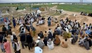 Afghan relatives attend a burial ceremony of victims who lost their lives following flash floods after heavy rainfall at a village in Baghlan-e-Markazi district of Baghlan province on May 11, 2024. (Photo by Atif Aryan / AFP)