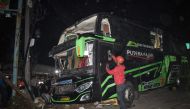 Officers check the damaged bus after a crash that killed 11 people, according to local police, in Subang, West Java, on May 11, 2024. (Photo by Timur Matahari / AFP)