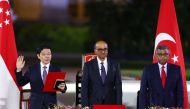 Singapore's incoming Prime Minister Lawrence Wong (L) is sworn in next to President Tharman Shanmugaratnam and Chief Justice Sundaresh Menon at the Istana in Singapore on May 15, 2024. (Photo by Edgar Su / Pool / AFP)
 