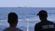 Philippine Coast Guard personnel aboard BRP Bagacay observe a China Coast Guard ship during the distribution of fuel and food to fishers by the civilian-led mission Atin Ito (This Is Ours) Coalition, in the disputed South China Sea on May 16, 2024. Photo by Ted ALJIBE / AFP