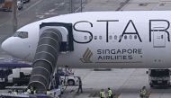 Officials gather around the Singapore Airlines Boeing 777-300ER airplane as it is parked on the tarmac at Suvarnabhumi International Airport in Bangkok on May 22, 2024. (Photo by Lillian Suwanrumpha / AFP)