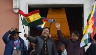 Bolivian President Luis Arce waves a Bolivian flag at the balcony of the Government Palace in La Paz on June 26, 2024. Photo by AIZAR RALDES / AFP.