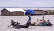 People transport their belongings on boats in a flood affected area at Morigaon district in Assam on July 1, 2024. (Photo by Biju Boro / AFP)