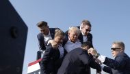  Republican presidential candidate former President Donald Trump pumps his fist as he is rushed offstage during a rally on July 13, 2024 in Butler, Pennsylvania. (Photo by Anna Moneymaker / GETTY IMAGES NORTH AMERICA / Getty Images via AFP)

