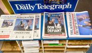The morning newspapers on display at a shop in Sydney on July 15, 2024, show the headlines and photos after the assassination attempt. (Photo by David Gray / AFP)