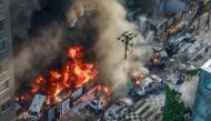 Smoke rises from the burning vehicles after protesters set them on fire near the Disaster Management Directorate office, during the ongoing anti-quota protest in Dhaka on July 18, 2024. (Photo by AFP)