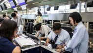 Airport staff manually check-in passengers at Hong Kong International Airport on July 19, 2024, due to a world wide Microsoft outage. (Photo by ISAAC LAWRENCE / AFP)