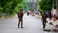 Bangladeshi soldiers stand guard along a street during a curfew amid the anti-quota protests, in Dhaka on July 23, 2024. (Photo by Munir UZ ZAMAN / AFP)
