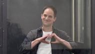 File: US journalist Evan Gershkovich, arrested on espionage charges, shapes a heart with his hands inside a defendants' cage after a hearing to consider an appeal on his extended pre-trial detention, at the The first court of appeal in Moscow on April 23, 2024. (Photo by Natalia Kolesnikova / AFP)