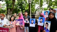 Relatives hold portraits of forcibly disappeared people, as they form a human chain to mark the International Day of the Victims of Enforced Disappearances, in Dhaka on August 30, 2024. (Photo by MUNIR UZ ZAMAN / AFP)
