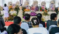 Mourners gather before prayers for the victims of a school bus fire near their coffins at Wat Khao Phraya Sangkharam School in Uthai Thani on October 3, 2024. Photo by Chanakarn Laosarakham / AFP