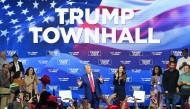 Former US President and Republican presidential candidate Donald Trump, with moderator and South Dakota Governor Kristi Noem (right), arrives for a town hall at the Greater Philadelphia Expo Center and Fairgrounds in Oaks, Pennsylvania, on October 14, 2024. (Photo by Jim Watson / AFP)