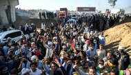 Supporters of jailed former prime minister Imran Khan's Pakistan Tehreek-e-Insaf (PTI) party shout slogans as they march towards Islamabad after clearing shipping containers placed by authorities during a demonstration demanding Khan's release, in Hasan Abdal in Punjab province on November 25, 2024. (Photo by Aamir QURESHI / AFP)
