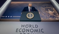 US President Donald Trump is seen on a large screen during his address by video conference at the World Economic Forum (WEF) annual meeting in Davos on January 23, 2025 (Photo by Fabrice Coffrini / AFP)
