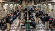 This image released by the Department of Defense shows undocumented migrants awaiting takeoff for a removal flight at the Tucson International Airport, Arizona, January 23, 2025. (Photo by Devlin Bishop / DVIDS / AFP)
