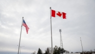 (Files) The Canadian and US flags fly near the Canada-US border in Blackpool, Quebec, Canada, on February 2, 2025.  (Photo by Andrej Ivanov / AFP)