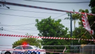 Police cordons are displayed to stop traffic after power lines fell across a road in Coorparoo in Brisbane on March 8, 2025, as cyclone Alfred crossed the southeast Queensland coast. (Photo by Patrick Hamilton / AFP)