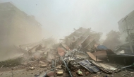 People inspect the debris of a collapsed building in Mandalay on March 28, 2025, after an earthquake. (Photo by AFP)

