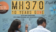 (Files) A woman writes a message during an event held by relatives of the passengers and supporters to mark the 10th year since the Malaysia Airlines flight MH370 disappeared from radar, in Subang Jaya on March 3, 2024. (Photo by Arif Kartono / AFP)

