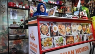 This picture taken on April 3, 2025 shows Afghan Citizen Cards (ACC) holder Benazir Raufi at the counter of her restaurant in Rawalpindi. (Photo by Aamir Qureshi / AFP) 