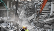Heavy construction equipment is used by rescue teams trying to find people trapped in the rubble at the site of an under-construction building collapse in Bangkok on March 29, 2025. (Photo by Manan Vatsyayana / AFP)

