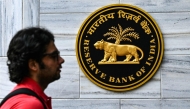 A pedestrian walks past a signage outside the Reserve Bank of India (RBI) headquarters in Mumbai on June 6, 2025. India's central bank cut interest rates more than expected on June 6, citing muted inflation and a need to kickstart economic growth as the impact of US tariffs weighed on the country's outlook. (Photo by Indranil MUKHERJEE / AFP)
