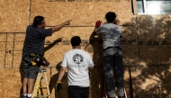 Workers board up a restaurant front in preparation for the No Kings protest in Los Angeles, on June 13, 2025. (Photo by Etienne Laurent / AFP)