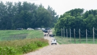 Law enforcement search the area around a vehicle on 301st Avenue on June 15, 2025 in Belle Plaine, Minnesota. Stephen Maturen/Getty Images/AFP 
 