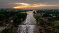 In an aerial view, the sun sets over the Guadalupe River on July 06, 2025 in Kerrville, Texas. (Photo by Brandon Bell / GETTY IMAGES NORTH AMERICA / Getty Images via AFP)
