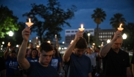 People hold up candles as they take part in a vigil for the victims of the floods over Fourth of July weekend, at Travis Park, in San Antonio, Texas, on July 7, 2025. Photo by Ronaldo Schemidt/ AFP