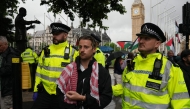 A protester is escorted away by police officers at a demonstration in support of the proscribed group Palestine Action calling for the recently imposed ban to be lifted, in Parliament Square, central London, on July 19, 2025. (Photo by CARLOS JASSO / AFP)
