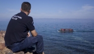 A Greek police officer looks at an overcrowded dinghy carrying refugees and migrants arriving. Reuters. File photo for representational purposes only.