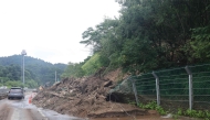 A road is covered with mud and debris carried by a mudslide due to heavy rain in Gapyeong county on July 20, 2025. Photo by YONHAP / AFP