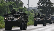 Royal Thai Army soldiers are pictured on armoured vehicles on a road in Chachoengsao province on July 24, 2025. Photo by Lillian SUWANRUMPHA / AFP.