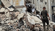 A Ukrainian law enforcement officer walks past a destroyed building of the Bilenkivska correctional colony following an air attack in Bilenke, Zaporizhzhia region on July 29, 2025. (Photo by Olexandr PAVLOV / AFP)
