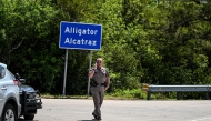 A Florida Highway Patrol officer looks on as protesters gather to demand the closure of the immigrant detention center known as 